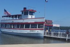 a large boat docked at a pier with an american flag on it's roof