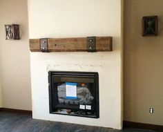 a white fireplace with some wood on the mantle