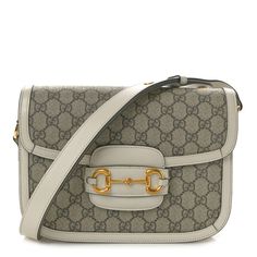 This is an authentic GUCCI GG Supreme Monogram Horsebit 1955 Shoulder Bag in Beige and Mystic White. This stylish shoulder bag is crafted of classic Gucci monogram GG canvas with white leather trim. The bag features an adjustable white leather shoulder strap, leather trim, and gold horsebit detail. The top flap opens to a compartmentalized beige fabric interior with zipper and patch pockets. This shoulder bag also features two additional button covers that can be used to cover the exposed studs Gucci Horsebit, Beige Bag, Gucci Monogram, Button Covers, Stylish Shoulder Bag, Beige Fabric, Leather Trim, White Leather, Leather Trims