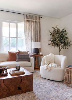 a living room filled with furniture and a tree in the corner on top of a coffee table