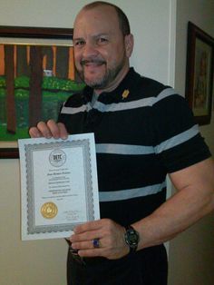 a man holding up a certificate in his hands