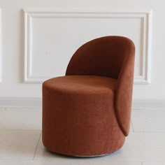 a brown chair sitting on top of a white floor next to a wall and window