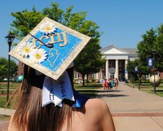 a woman wearing a graduation cap with daisies on it