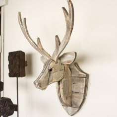 a wooden deer head mounted to the side of a wall