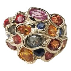 14 karat multicolored sapphire cluster ring, containing 25 round sapphires (orange, yellow, blue, green and lavender) of very fine gem quality weighing 6.43cts. This ring is a size 7 but we will size to fit for free. Luxury Multi-stone Gold-toned Gemstones, Luxury Multi-stone Classic Sapphire Ring, Luxury Elegant Cluster Gemstones, Luxury Multicolor Round Gemstones, Luxury 22k Gold Multicolor Jewelry, Luxury Multicolor Jewels Gemstones, Multicolor Sapphire Multi-stone Ring, Multicolor Multi-stone Sapphire Ring, Multicolor Sapphire Ring In Fine Jewelry Style