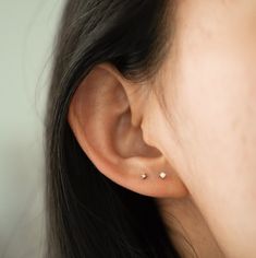 a close up of a person's ear with two piercings