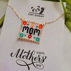 a mother's day card with a cross stitch necklace on it and a panda bear