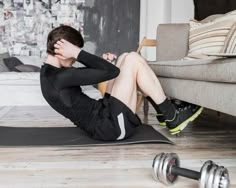 a man sitting on a yoga mat with his hands behind his head