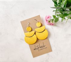 Luxurious sunny yellow leather in a modern shape. These statement earrings are available in 3 colours - white, black, and this bright yellow! Summery, lightweight, bold style with 3 hook finishes.•••••••••••••••••••••••••••••••••••••••••••••••••••••••••••••• • ORDERING • These leather earrings are approx 3" long with hook. These earrings have hypo-allergenic ear wires. Nickel and lead free. Choose one of our finishes of ear wire from the drop down. Available finishes are:• Raw Brass Hooks• Stamp Luxury Handmade Yellow Earrings, Handmade Yellow Brass Earrings, Hand Painted Yellow Enamel Earrings, Bold Yellow Earrings, Artistic Yellow Nickel-free Earrings, Brass Hooks, Earrings Accessories, Sunny Yellow, Bold Style