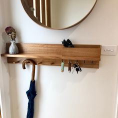 a coat rack with umbrellas and keys hanging from it's hooks on the wall