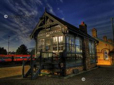 an old train station at night with the sky in the background and clouds above it