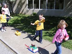 three children are playing with toys on the sidewalk