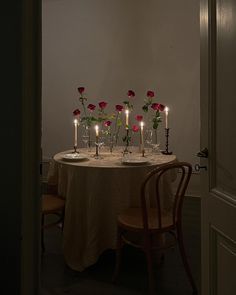 the table is set with candles and flowers in vases on top of each other