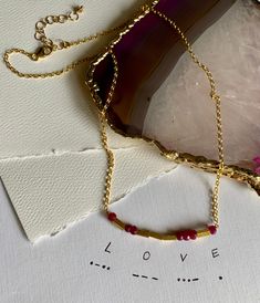 "The word \"LOVE\" is encoded in this beautiful necklace. Arrangement of Ruby \"dots\" and Gold vermeil \"dashes\" spell the cherished word in Morse code. Linked on a delicate cable chain, the overall length of the necklace measures 16\" with 2\" extender. The Ruby stones measure about 4mm and the length of the word is 48mm. Ships in a small gift box To learn more about my jewelry, please visit:  www.katarina-anna-design.com @katarina.anna.design" Necklace Arrangement, Love Morse Code, Code Morse, Morse Code Necklace, Blue Topaz Earrings, Morse Code, Small Gift Boxes, Ruby Stone, Topaz Earrings