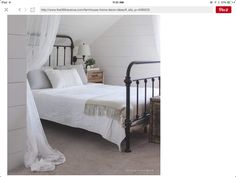 a bed with white sheets and pillows in a room