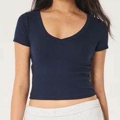 Nwt Hollister Navy Blue Cotton Blend V-Neck Baby Tee Cotton Blend V-Neck Baby Tee A Super Soft And Ultra-Comfy T-Shirt With Short Sleeves And V-Neckline. Ribbed Fabric. Slim Fit. This Item Is Available In Extended Lengths: Short - 17" Regular - 19" Long - 21" Imported. Body:57% Cotton, 38% Polyester, 5% Elastane Machine Wash Cold, With Like Colors Only Non-Chlorine Bleach Tumble Dry Low Low Iron If Needed Do Not Dry Clean Low Low, Hollister Tops, Low Iron, Comfy Fits, Ribbed Fabric, Baby Tee, Infant Tees, Hollister, Cotton Blend