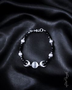 In honour of Artemis, Goddess of the wilds and Goddess of the moon. She who wears the crescent moon crown. An enchanting beaded bracelet featuring a Selenite sphere framed by crescent moons, and strung between black Onyx and silver freshwater pearls. This bracelet depicts the Triple Goddess symbol, the Selenite bead in the centre symbolising the full moon with a waxing and waning crescent on either side.  The crescent moon beads are produced in sterling silver and are uniquely textured by hand g Silver Bracelet With Moon Charm And Round Beads, Silver Bracelets With Moon Charm And Round Beads, Celestial Round Beads Jewelry For Festival, Celestial Style Festival Jewelry With Round Beads, Bohemian Moon Phase Round Beaded Jewelry, Mystical Adjustable Moon Phase Jewelry, Adjustable Mystical Moon Phase Jewelry, Silver Spiritual Bracelets With Moon Phase, Bohemian Moon Phase Bracelet