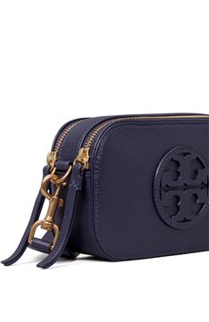 A stacked-T logo appliqué centers a rich leather crossbody bag designed with divided compartments and a detachable webbing strap for modern appeal. Top zip closure Removable, crossbody strap Interior wall pocket; dual interior compartments with center divider Structured silhouette with flat base for stability Faux-leather lining Leather/cotton/polyester Imported Tory Burch Purse, Tory Burch Crossbody, Leather Camera Bag, Womens Designer Handbags, Designer Crossbody, Tory Burch Miller, Designer Crossbody Bags, Mini Crossbody Bag, Mini Crossbody