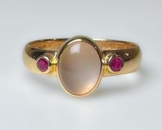 Stunning vintage, midcentury to 1970s...not entirely sure of its age. It does have an older hallmark. This is elegantly crafted ring with a comfortable low profile.  Featuring a clean luminescent 1.5ct Moonstone, flanked by two red Ruby's. Very pretty ring. 3.7g 14k solid yellow gold Hallmarked 4mm wide band Moonstone 1.5 ct Rubies 2 mm ea (.10ct) S 8 Us Resizable Excellent vintage condition Unique Ring Setting, Moonstone Gold Ring, Signet Rings Women Vintage, Wizard Jewelry, Vintage Ruby Ring, Rubin Ring, Ruby Ring Vintage, Moonstone Rings, June Birthstone Ring