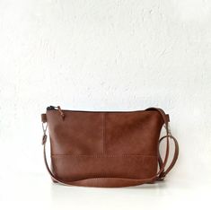 Brown leather crossbody bag The perfect day bag - great size that will fit all your essentials. It is light and comfortable on the shoulder.  Made of vegan leather in cognac brown color.  The lining is made of solid light brown cotton fabric.  * Black zipper closure *4 slip pockets *Detachable and adjustable strap *Silver-tone hardware  Dimensions:  Width: 11 in Height: 7.5 in Depth: 2.5 in Strap: approx. 49 in Minimalist Brown Clutch Bag, Minimalist Soft Leather Crossbody Satchel, Minimalist Crossbody Shoulder Bag As Gift, Brown Cotton Fabric, Brown Crossbody Purse, Brown Leather Crossbody Bag, Everyday Purse, Minimalist Bag, Brown Crossbody