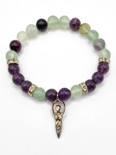 Start each day with a clear mind and positive energy with the Earth Goddess Bracelet. Crafted using genuine rainbow fluorite and amethyst crystal beads adorned with a silver goddess charm, this bracelet will guide you through daily challenges with confidence and calm. Rainbow Fluorite & Amethyst Properties: Fluorite acts like a vacuum cleaner for your mind, clearing it of confusion, cluttered thoughts, negativity, and any thoughts that no longer serve you. Fluorite is known as the "Genius Stone" Spiritual Round Beads Charm Bracelet For Healing, Spiritual Charm Bracelet With 8mm Beads For Healing, Silver Amethyst Beaded Bracelets For Meditation, Silver Spiritual Crystal Bracelet For Healing, Spiritual Amethyst Crystal Bracelet, Crystal Bracelet With Round Beads For Meditation, Meditation Crystal Bracelet With Round Beads, Amethyst Beaded Bracelet For Meditation, Fluorite Gemstone Beads Bracelets For Healing