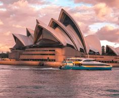 a boat is in front of the sydney opera house