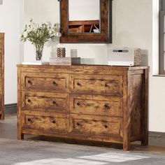 a wooden dresser sitting in front of a mirror