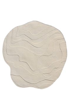 a white circular rug with wavy lines on the top and bottom, against a white background