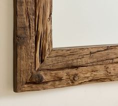 a wooden mirror hanging on the wall