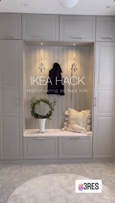 a room with white cabinets and a wreath on the window sill in front of it