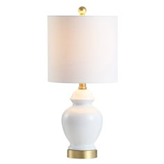 a white lamp with a gold base and a white shade on the top of it