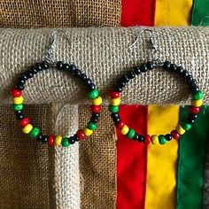 two pairs of beaded hoop earrings sitting on top of a table next to a bag