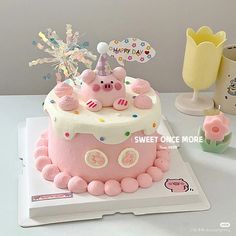 a birthday cake with pink frosting and decorations