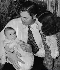 an old black and white photo of a man holding a baby with two women looking at him