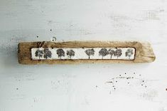 a piece of wood that has been decorated with black and white tree designs on it