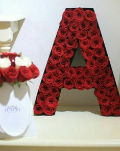 the letters are made out of red roses and white vases with flowers in them