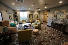 a living room filled with lots of furniture next to a fire place in a building