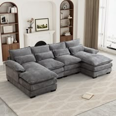 a large gray sectional sofa sitting on top of a white rug in a living room