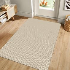 a beige and white area rug on the floor in a room with wooden floors, a basket