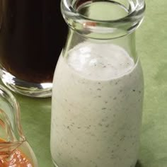 there is a glass bottle with some liquid in it next to another jar on the table