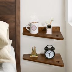 two wooden shelves with coffee mugs and alarm clock on them