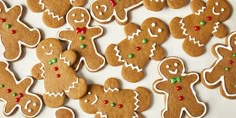 some very pretty decorated ginger cookies on a table with green and red candies around them