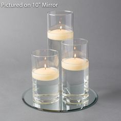 three candles are sitting on a glass plate