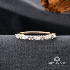 a gold wedding band with five stones on top and the words artlandus written in white