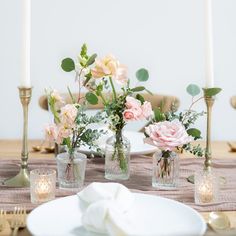 the table is set with flowers and candles