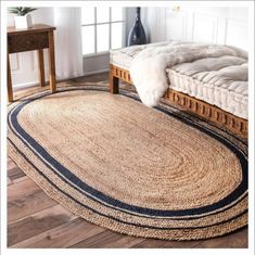 a large round rug in the corner of a room with a bed and side table