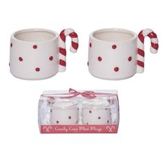 two white ceramic mugs with candy cane handles and red polka dot design on them