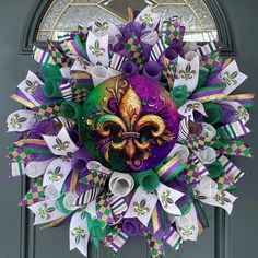 a purple and green mardi gras wreath with a mask on it's front door