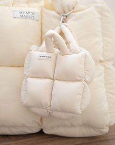 a white bag sitting on top of a pile of pillows