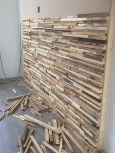 a pile of wood sitting on top of a floor next to a wall